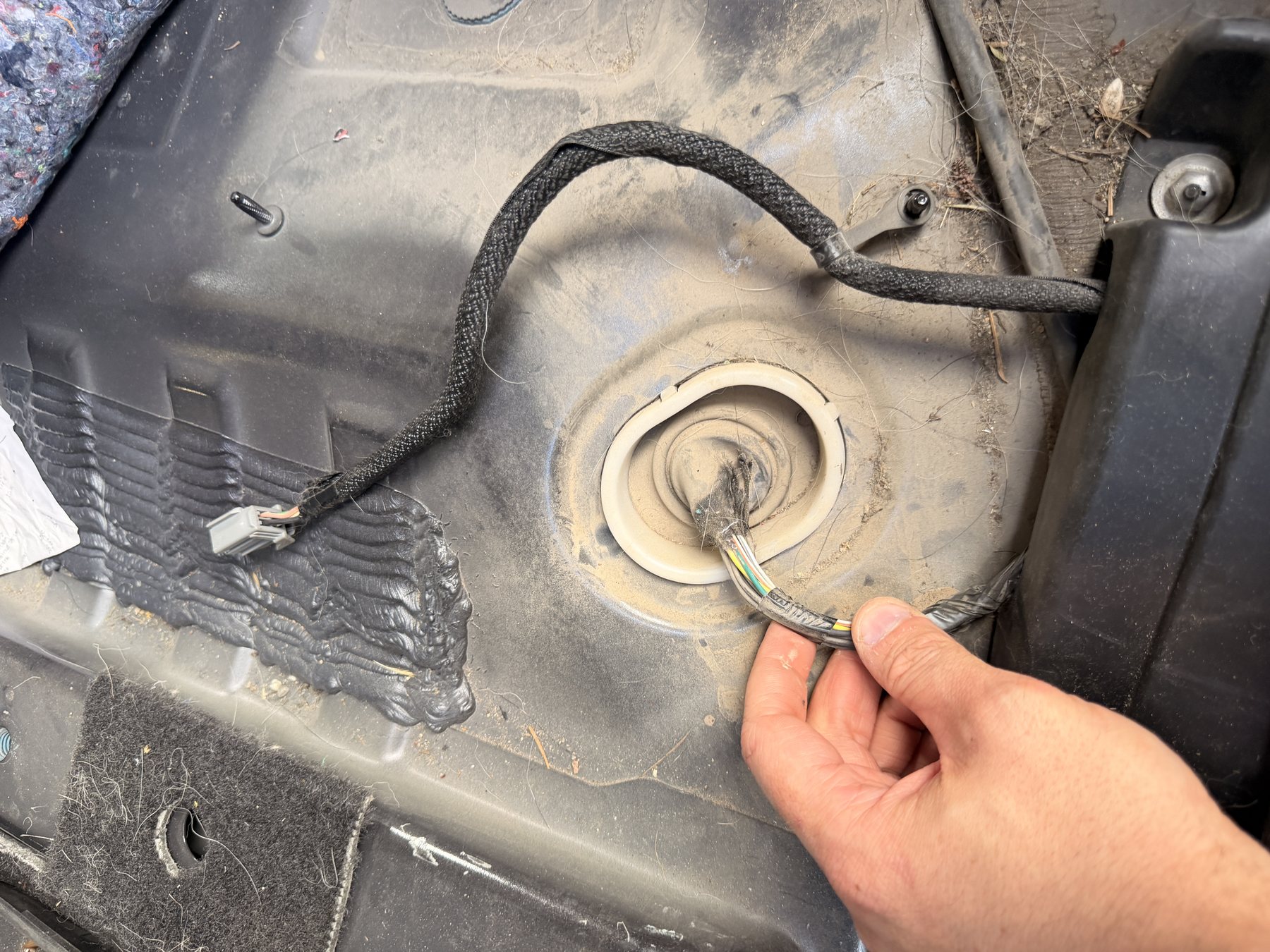 The existing floor pan grommet with room alongside the wires already passing through it